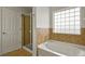 Bright bathroom features a soaking tub with tile surround and a glass-enclosed shower at 3672 S Perth Cir # 101, Aurora, CO 80013