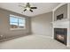 Spacious bedroom featuring a cozy fireplace, ceiling fan, and a bright window with neighborhood views at 3672 S Perth Cir # 101, Aurora, CO 80013