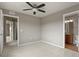 Neutral bedroom showcasing a bathroom entrance and a bright open hallway at 3672 S Perth Cir # 101, Aurora, CO 80013