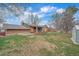 Spacious backyard with a brick home featuring a covered porch and a well-maintained lawn at 11972 W Dakota Dr, Lakewood, CO 80228