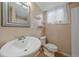 Bright bathroom featuring a pedestal sink, toilet, and natural light at 11972 W Dakota Dr, Lakewood, CO 80228