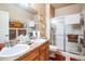 Bathroom features a double sink vanity and glass shower doors at 10487 W Hampden Ave # 101, Lakewood, CO 80227