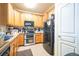 Kitchen featuring oak cabinets, black appliances, double oven, and tile flooring at 10487 W Hampden Ave # 101, Lakewood, CO 80227