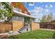 Landscaped backyard with wood fence, green grass, and seating area at 190 W Archer Pl, Denver, CO 80223