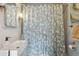 Bathroom with modern sink, shower and decorative shower curtain and light fixture at 190 W Archer Pl, Denver, CO 80223