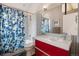 Bright bathroom featuring tile backsplash, red vanity, and shower with patterned curtain at 190 W Archer Pl, Denver, CO 80223