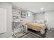 Cozy bedroom with a bed and desk area with open shelving, all in a finished basement with updated flooring at 190 W Archer Pl, Denver, CO 80223