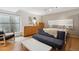 Bedroom featuring a gray sofa, hardwood dressers, and large bright window at 190 W Archer Pl, Denver, CO 80223