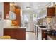 Well-lit kitchen features wooden cabinets, hardwood floors, stainless steel appliances, and a door to the outside at 190 W Archer Pl, Denver, CO 80223