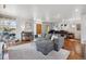 Bright living room with hardwood floors, gray sectional sofa, piano, and large windows at 190 W Archer Pl, Denver, CO 80223