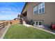 A cozy backyard featuring artificial grass and a staircase leading to a covered patio at 4475 Hidden Gulch Rd, Castle Rock, CO 80104