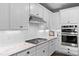 Close-up of the kitchen featuring white cabinets, granite countertops, and stainless steel appliances at 4475 Hidden Gulch Rd, Castle Rock, CO 80104