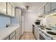 Compact kitchen featuring white appliances, tile flooring, and ample cabinet storage at 12174 Melody Dr # 203, Westminster, CO 80234