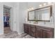 Bathroom featuring a double sink vanity, decorative mirrors, and a large walk-in closet at 9028 S Catawba St, Aurora, CO 80016