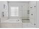 Modern bathroom boasts a separate tub and a glass-enclosed shower, all in neutral tones at 9028 S Catawba St, Aurora, CO 80016