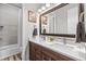 This well-lit bathroom features a double vanity, a large mirror, and a shower/tub combo at 9028 S Catawba St, Aurora, CO 80016