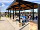 Outdoor covered patio area with tables, chairs and a cooking area at 9028 S Catawba St, Aurora, CO 80016