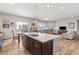 Open-concept kitchen with stainless steel appliances, custom cabinets, granite countertops, and island with seating at 9028 S Catawba St, Aurora, CO 80016