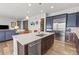 Open-concept kitchen with stainless steel appliances, custom cabinets, granite countertops, and island with seating at 9028 S Catawba St, Aurora, CO 80016