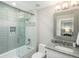 Modern bathroom featuring a glass-enclosed tub/shower combination and a granite vanity at 18 Foxtail Cir, Englewood, CO 80113