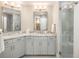 Light and bright bathroom featuring a granite countertop, white cabinets, and a glass shower at 18 Foxtail Cir, Englewood, CO 80113