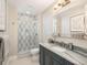Bright bathroom featuring marble countertops, updated fixtures, and a glass-enclosed shower at 18 Foxtail Cir, Englewood, CO 80113