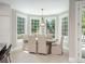 Bright dining room with large windows, elegant chandelier, and seating for six at 18 Foxtail Cir, Englewood, CO 80113