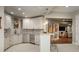 Basement kitchen features white cabinetry, marble countertops, stainless steel appliances, and stylish bar seating at 18 Foxtail Cir, Englewood, CO 80113