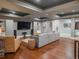 Open-concept living area with hardwood floors, a large sectional sofa, and a cozy reading nook at 18 Foxtail Cir, Englewood, CO 80113