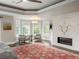 Bright main bedroom boasts a fireplace, ceiling fan, and seating area by bay windows overlooking the yard at 18 Foxtail Cir, Englewood, CO 80113