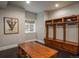 Functional mudroom with custom wooden lockers, storage benches, and a decorative window at 18 Foxtail Cir, Englewood, CO 80113