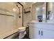 Stylish bathroom featuring a tiled shower, white vanity, modern fixtures, and wood-look flooring at 3344 Carabiner St, Castle Rock, CO 80108