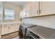 Well-organized laundry room with abundant cabinet space and modern washer and dryer units at 3344 Carabiner St, Castle Rock, CO 80108