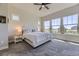 Bright main bedroom with large windows, plush carpet, ceiling fan, and minimalist decor at 3344 Carabiner St, Castle Rock, CO 80108
