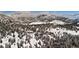 Panoramic aerial view of a snow-covered property with home and beautiful mountain scenery at 3999 Evans Ranch Rd, Evergreen, CO 80439