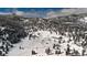 Scenic aerial view of a snow-covered property featuring homes nestled within a forest at 3999 Evans Ranch Rd, Evergreen, CO 80439