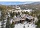 Stunning aerial view of the luxurious log home and its expansive, snow-covered surroundings at 3999 Evans Ranch Rd, Evergreen, CO 80439