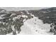 Serene aerial view of a snow-covered valley landscape with scattered homes and mountains in the background at 3999 Evans Ranch Rd, Evergreen, CO 80439