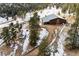 Aerial view of property with large barn, guest house, and snowy landscape at 3999 Evans Ranch Rd, Evergreen, CO 80439