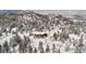 Stunning mountain home nestled amongst snow-covered trees with an amazing view of the surrounding landscape at 3999 Evans Ranch Rd, Evergreen, CO 80439