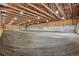 Spacious barn interior featuring wood beam construction and an expansive riding area at 3999 Evans Ranch Rd, Evergreen, CO 80439