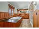 Luxury bathroom featuring a soaking tub, wood finishes, and views from large windows at 3999 Evans Ranch Rd, Evergreen, CO 80439