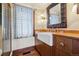 Classic bathroom featuring custom wood cabinetry, a farmhouse sink, and elegant brass fixtures at 3999 Evans Ranch Rd, Evergreen, CO 80439