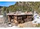 Magnificent log home with stone accents, multiple balconies, and a mountain backdrop at 3999 Evans Ranch Rd, Evergreen, CO 80439