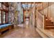 Grand foyer with stone walls, log beams, high ceilings, and staircase at 3999 Evans Ranch Rd, Evergreen, CO 80439