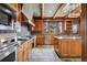 Spacious kitchen featuring stainless steel appliances, stone floors, and natural wood cabinets at 3999 Evans Ranch Rd, Evergreen, CO 80439