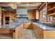 Stylish kitchen with custom cabinets, granite countertops, and a stainless steel hood at 3999 Evans Ranch Rd, Evergreen, CO 80439