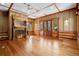 Spacious living room with fireplace, wood floors, and doors to the outside at 3999 Evans Ranch Rd, Evergreen, CO 80439