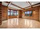 Spacious living room with natural light, log walls, and hardwood floors at 3999 Evans Ranch Rd, Evergreen, CO 80439