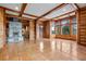 Bright living room with a stone fireplace and windows overlooking the backyard at 3999 Evans Ranch Rd, Evergreen, CO 80439
